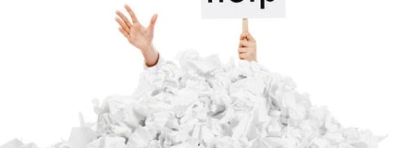 Hands buried in paper work pile, asking for help. Featured on XCL website